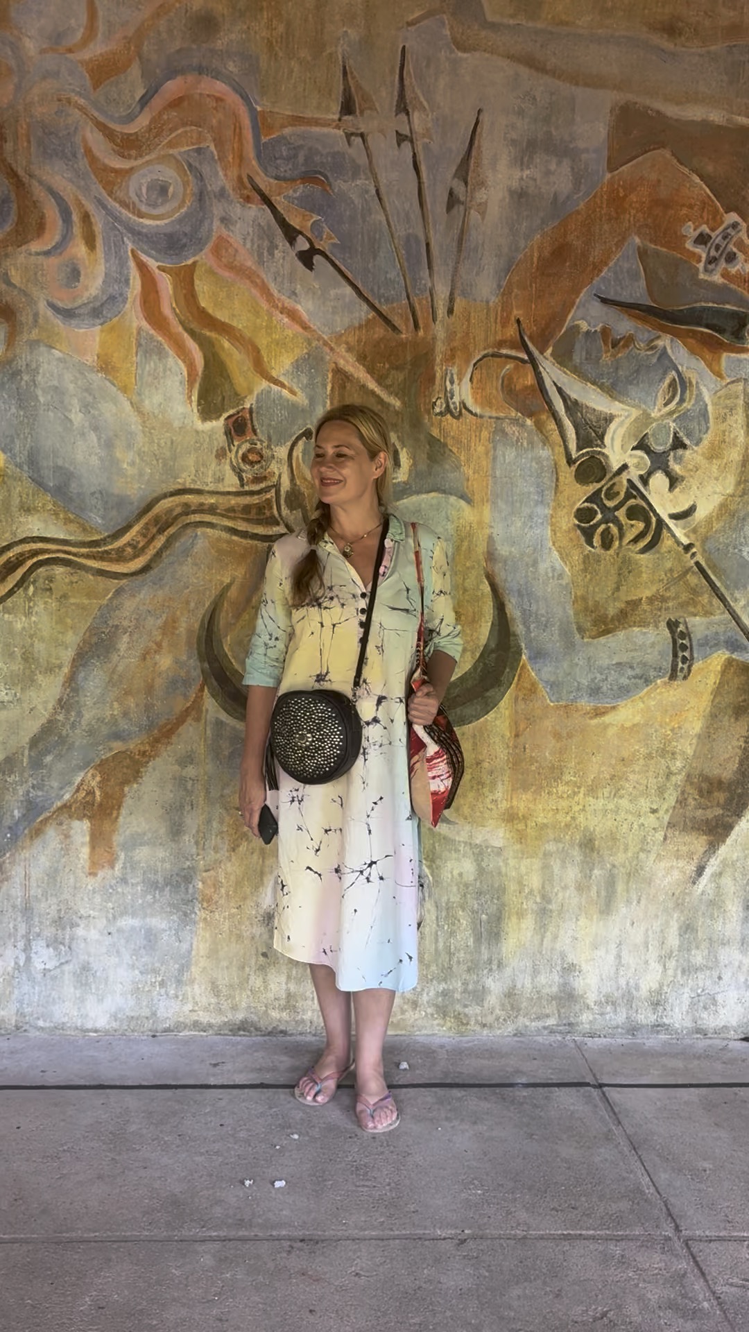 Rebecca Russell-Turner standing in front of a large painted mural in Sri Lanka